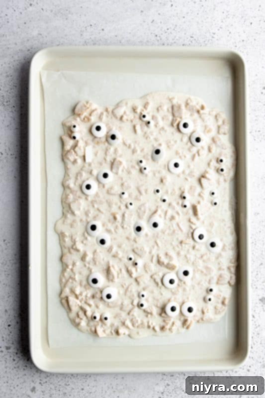 Step 7: Edible candy eyes placed on the spread mummy bark mixture.