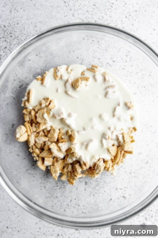 Step 4: Melted white chocolate being poured over crushed Oreos.