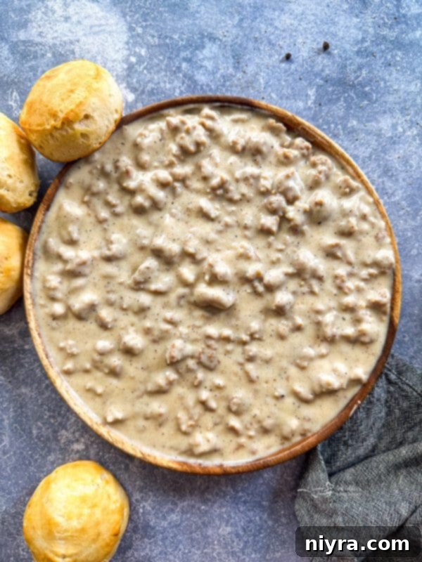 Close-up of creamy sausage gravy in a skillet, showcasing its rich texture and inviting aroma.