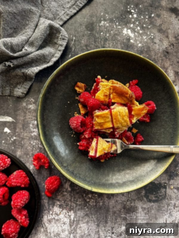 A close-up of mixed dry ingredients and raspberries in bowls