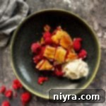 Close up of a slice of raspberry pie and ice cream on a green plate