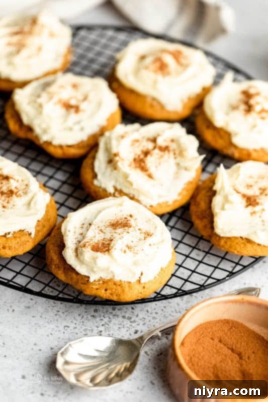 Close-up of frosted soft pumpkin cookies on a wooden surface