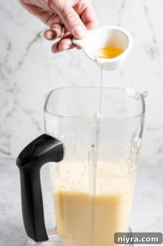 Homemade Blender Eggnog 11 Step 5: Pouring bourbon and rum into the blender with other ingredients.