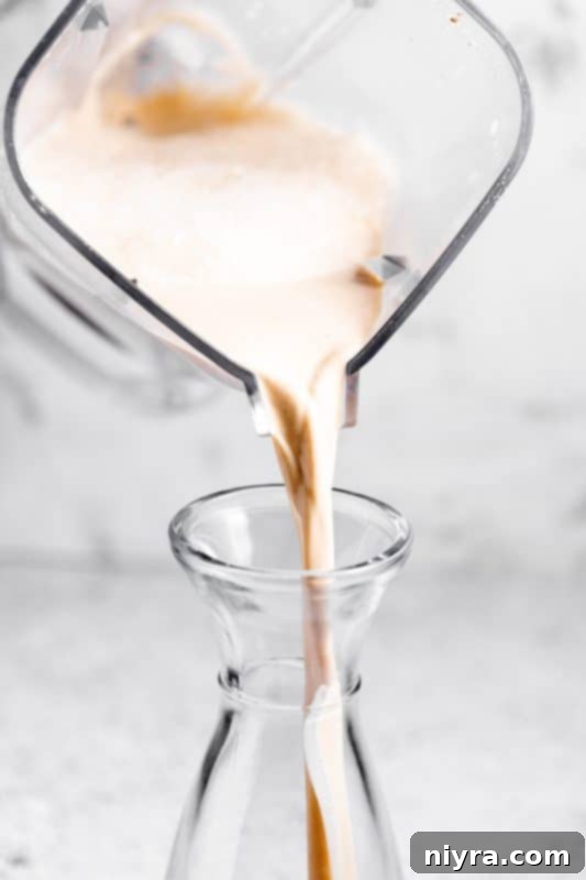 Homemade Blender Eggnog 14 Step 8: Pouring finished homemade eggnog into a glass jar for chilling.