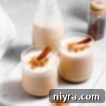 Homemade Blender Eggnog 21 Two glasses of eggnog topped with a cinnamon stick.