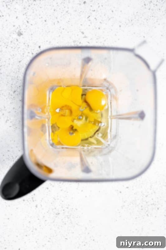 Homemade Blender Eggnog 7 Step 1: Adding fresh pasteurized eggs to a blender.