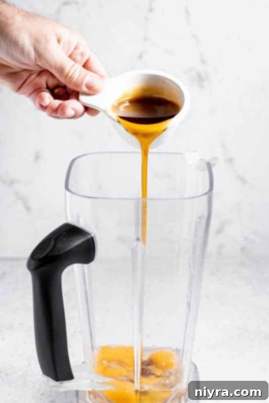 Homemade Blender Eggnog 8 Step 2: Pouring maple syrup into the blender with the eggs.