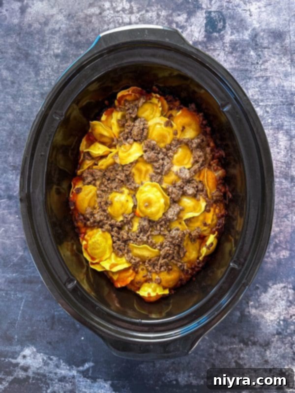 Step 6: Repeating the layers with the remaining ingredients for Easy Crockpot Lasagna.