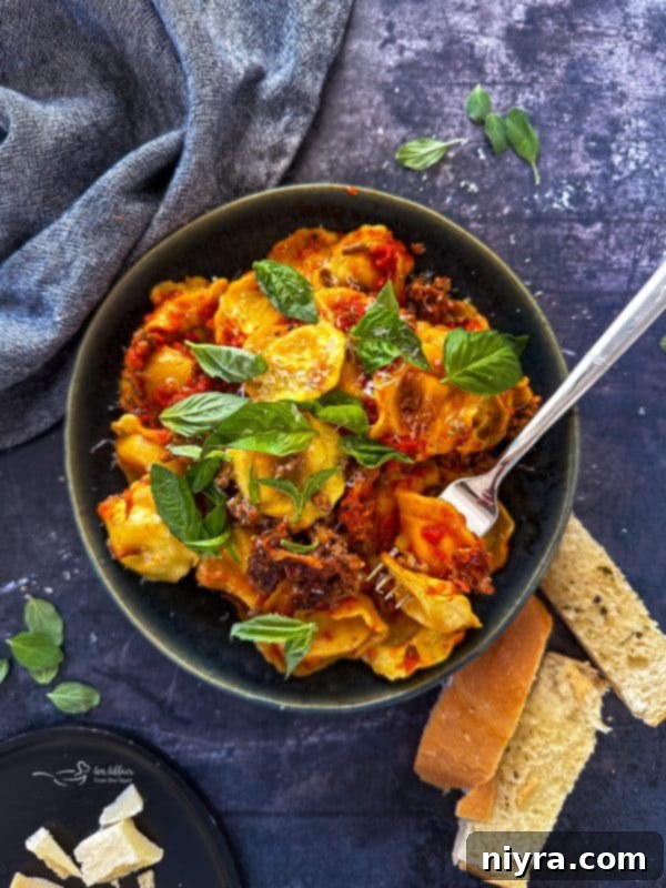 A dish of slow cooker ravioli lasagna, freshly cooked and covered in melted cheese.