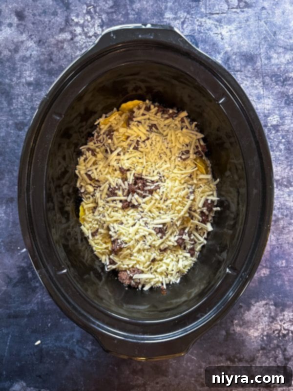 Step 5: Layering half of the ground beef mixture over the ravioli.