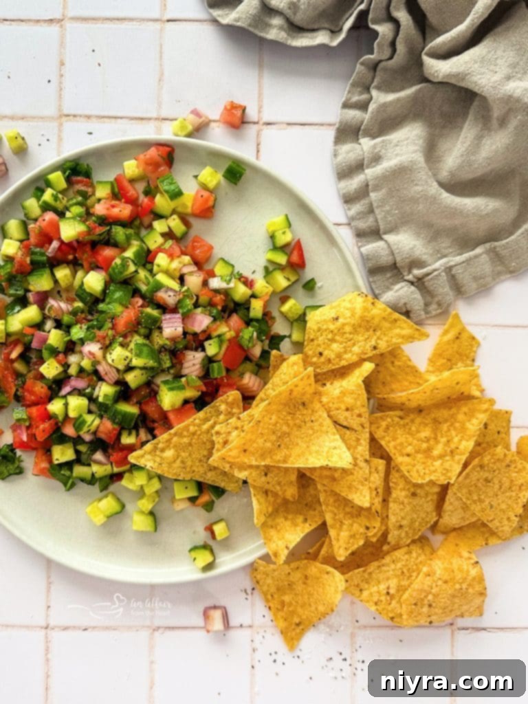 Freshly made cucumber salsa in a white bowl, garnished with cilantro.