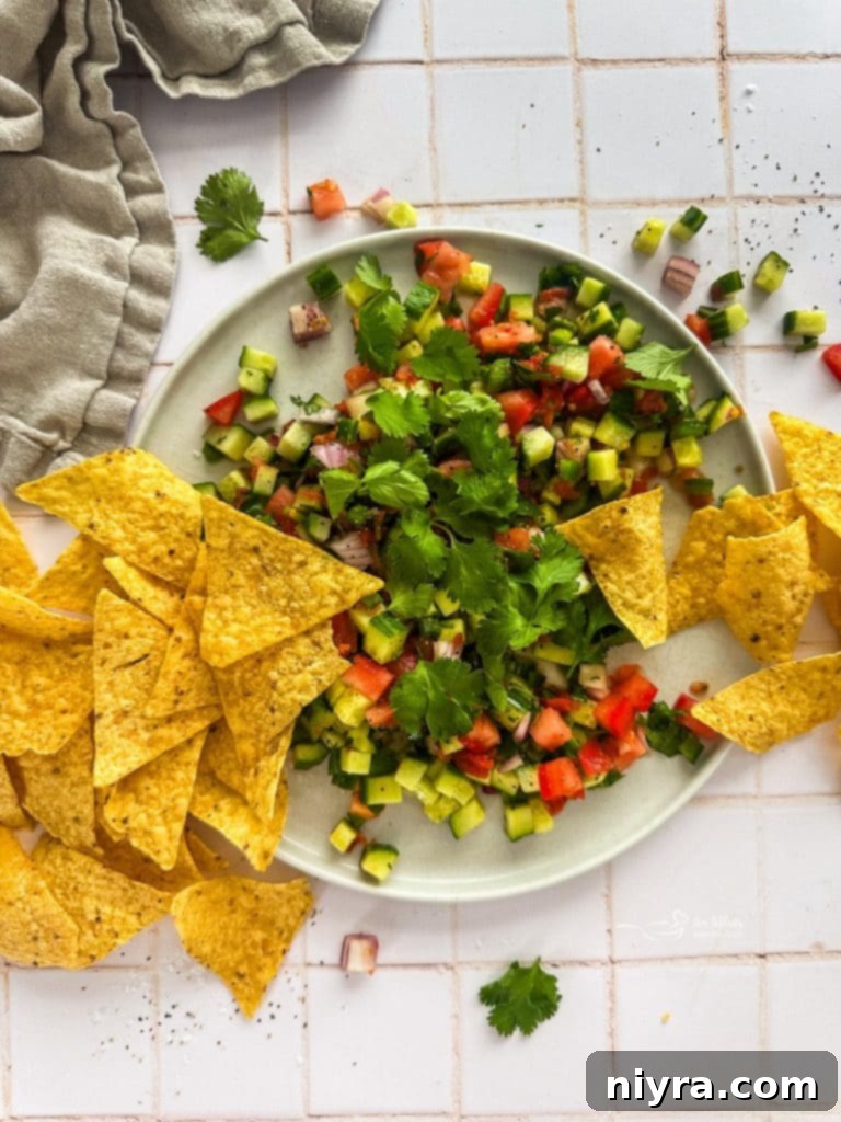 Close-up of fresh cucumber salsa with tortilla chips.