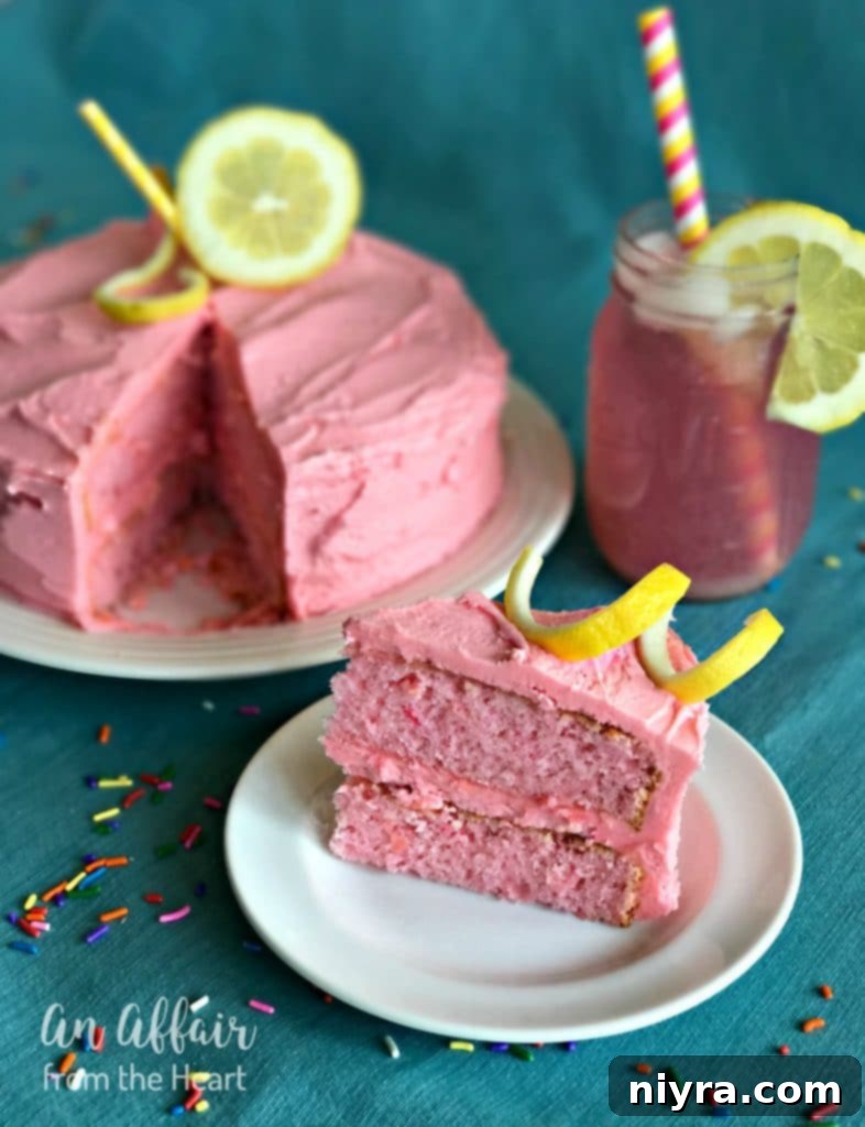 Close-up of Pink Lemonade Cake, showcasing its fluffy texture and generous pink frosting, with a hint of lemon zest on top.