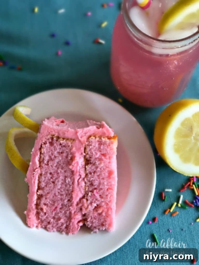 Another perspective of the Pink Lemonade Cake, highlighting the smooth frosting, vibrant pink color, and delicate fork mark.