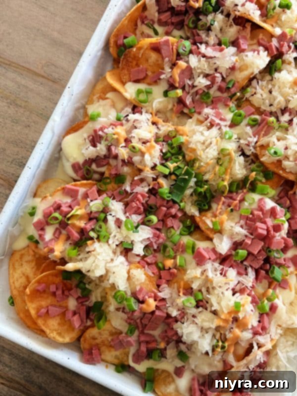 Reuben's Tangy Nacho Tower 11 Reuben Irish nachos on a sheet pan loaded with toppings