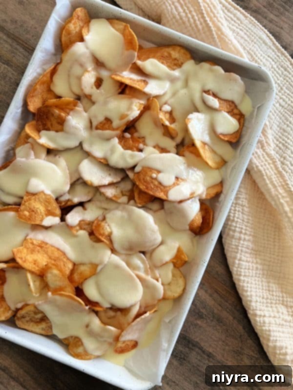 Reuben's Tangy Nacho Tower 8 Pouring cheese sauce over potato chips