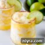 Close up of Frozen Pineapple Margarita garnished with a slice of lime.