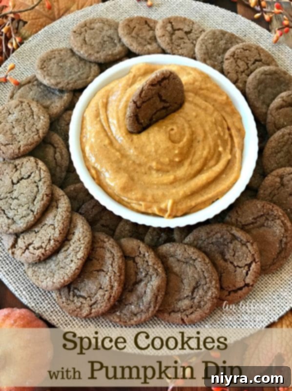 A beautifully presented bowl of pumpkin dip surrounded by a generous amount of spice cookies on a serving platter.