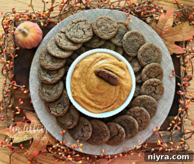 A festive platter of golden-brown spice cookies surrounding a vibrant orange pumpkin dip.