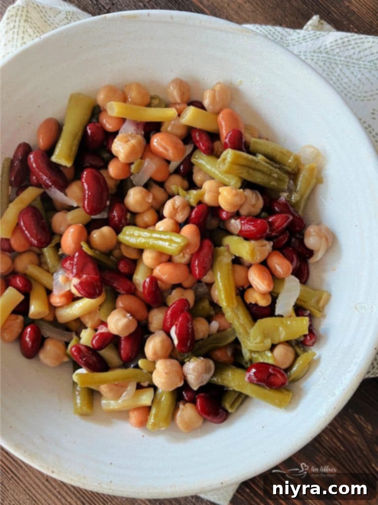 Grilled Sweet and Smoky Chicken served alongside a vibrant Paisley Farm Five Bean Salad in a bowl.