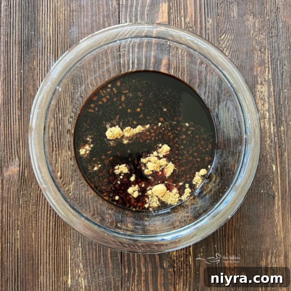 Ingredients for the sweet and smoky marinade being whisked together in a small bowl.