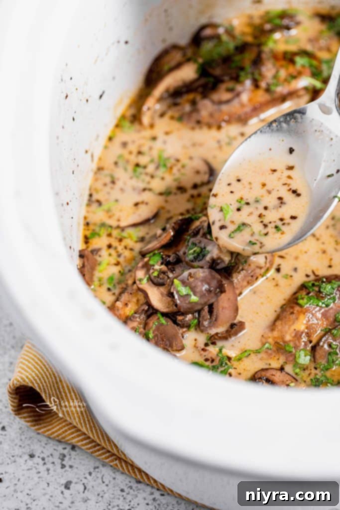 Easy Slow Cooker Chicken Marsala 4 Crock Pot Marsala Chicken simmering in a slow cooker with a rich, dark sauce and mushrooms.