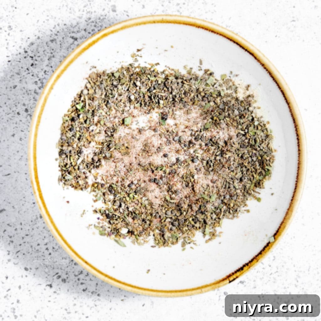 Easy Slow Cooker Chicken Marsala 6 Chicken breasts seasoned with herbs and spices in a small bowl, ready for cooking.