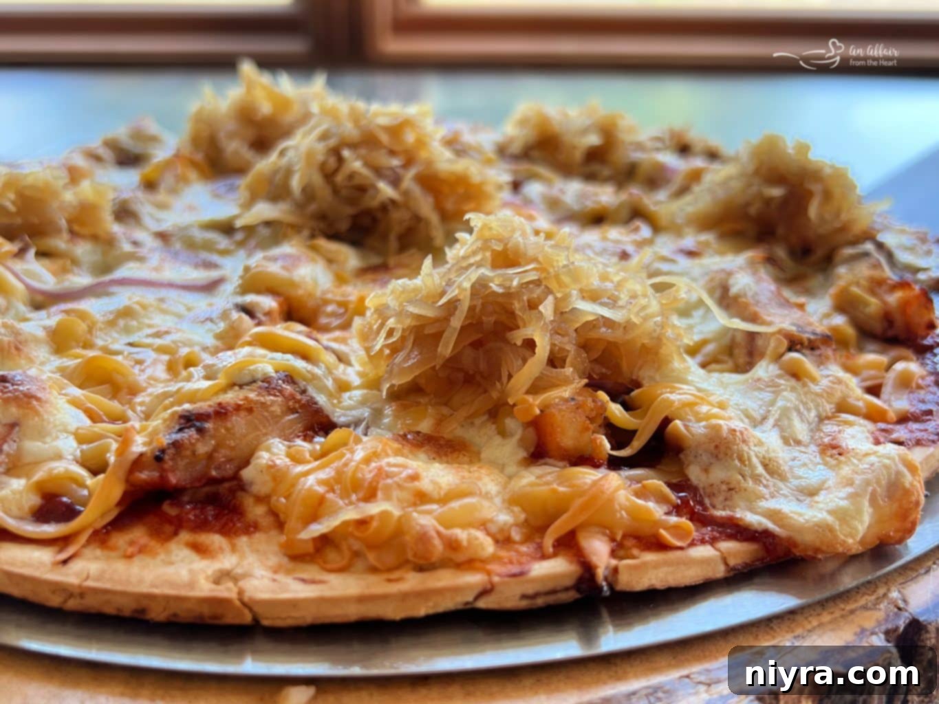 Freshly grilled BBQ Chicken Pizza being removed from the grill.