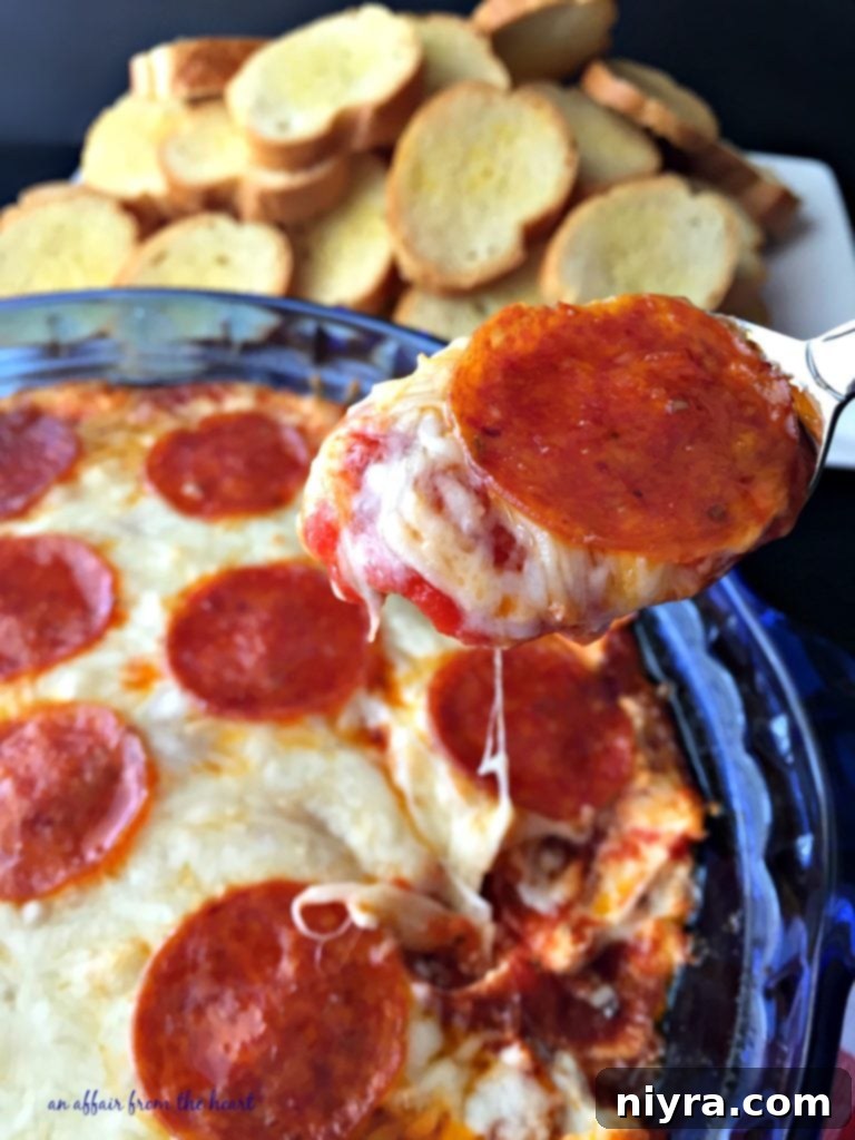 A spoonful of bubbly, cheesy Pizza Dip ready to be enjoyed.