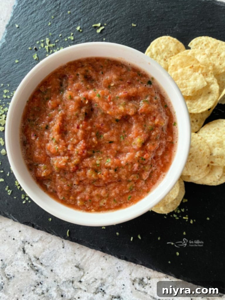 Overhead view of Easy Dump Salsa served with tortilla chips on a rustic slate board.