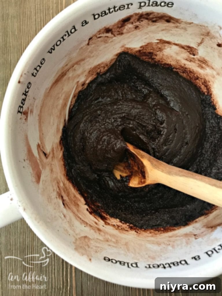 Wet ingredients being added to dry ingredients for brownie batter