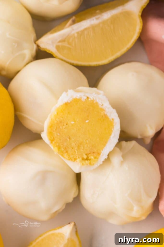 A collection of lemon truffles, some plain, some garnished, with fresh lemons in the background.