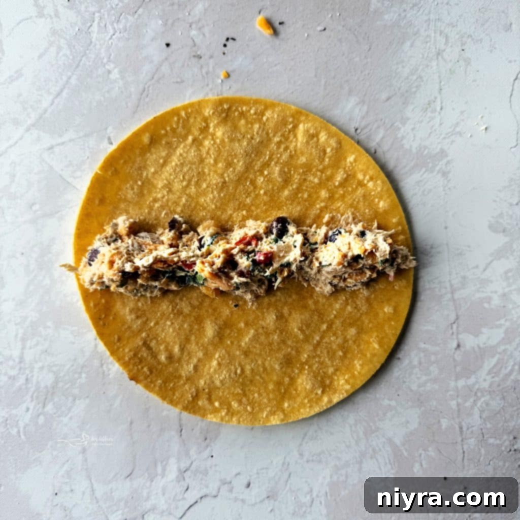 Softening corn tortillas in a skillet before rolling