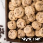Bite-Sized Chocolate Chip Delights 15 Mini Chocolate Chip Cookies stacked on a sheet pan