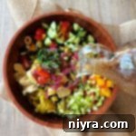 Mediterranean Dressing being poured over Pickled Vegetable Salad.