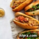 Closer view of four Sauerkraut and Kielbasa Hoagies on a tan tea towel.