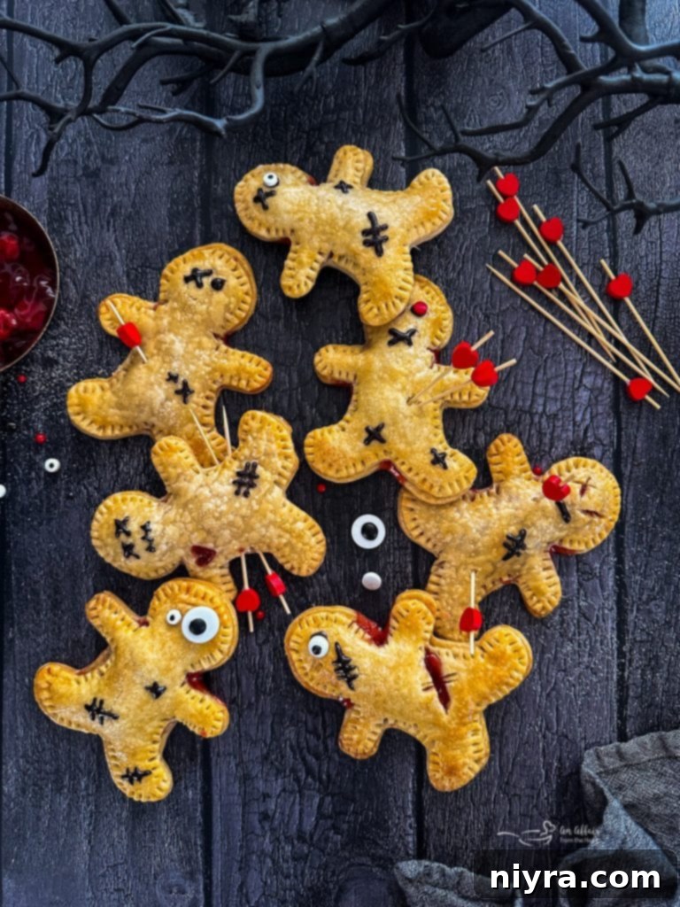 Three Voodoo Doll Hand Pies on a white plate with cherry filling.