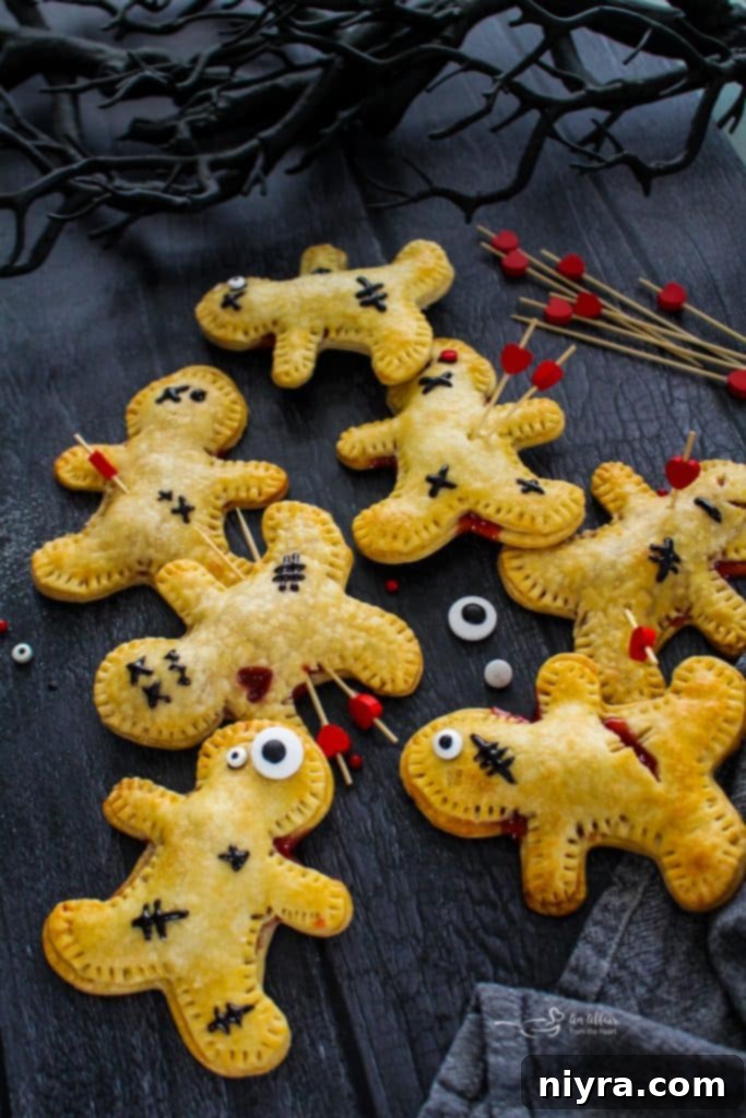 Several Voodoo Doll Hand Pies on a white baking tray