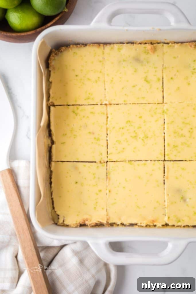 Zesty Key Lime Pie Bars 11 Baked Key Lime Pie Bars cooling on a wire rack, still in the baking pan, after being removed from the oven.