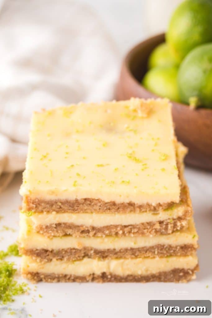 Zesty Key Lime Pie Bars 3 Several Key Lime Pie Bars arranged on a white serving platter, showing off their neat slices and vibrant green color.
