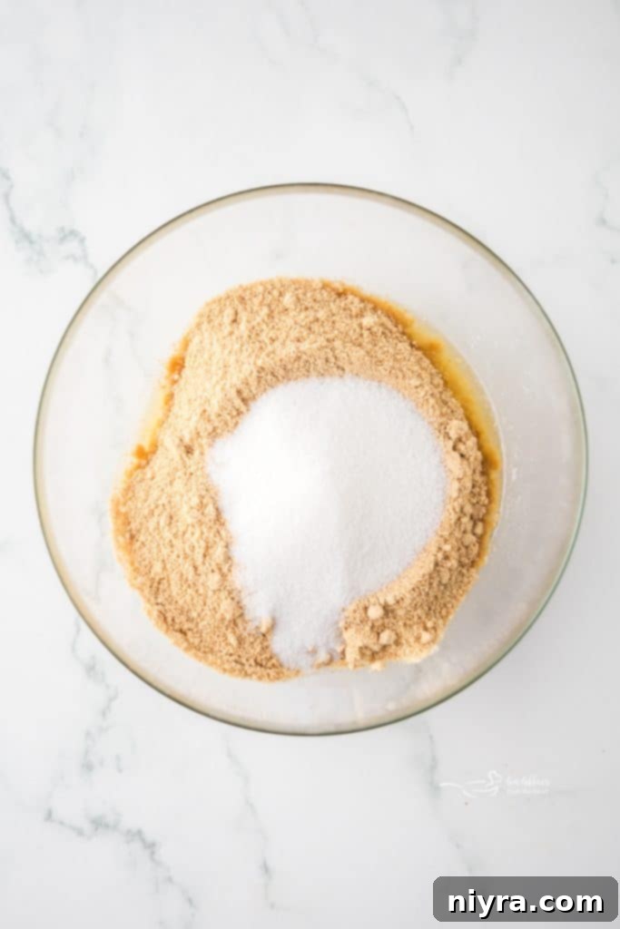 Zesty Key Lime Pie Bars 7 Melted butter being stirred into graham cracker crumbs in a bowl to make the crust.