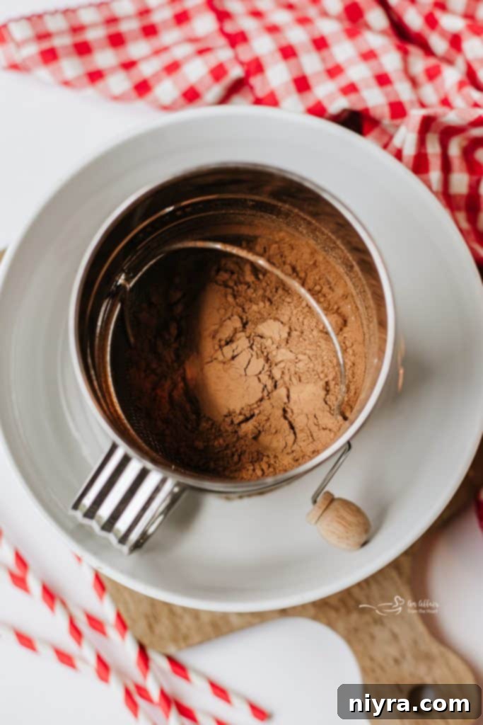 Homemade Copycat Nesquik Recipe 5 Sifting cocoa powder, sugar, and salt into a bowl to create a fine chocolate milk mix.