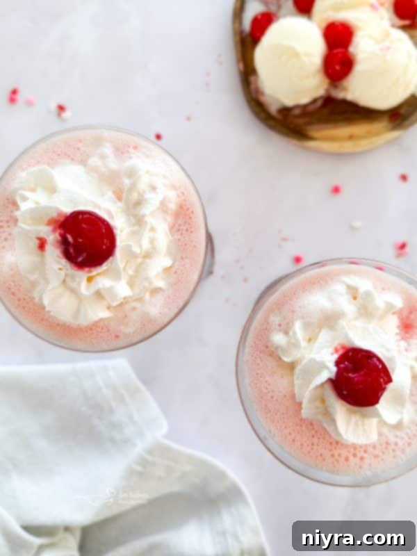 Pink Velvet Dream 3 Two Pink Squirrel cocktails garnished with whipped cream and cherries.