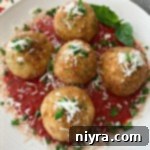Close up of Arancini - Three Cheese Fried Risotto Balls on a white plate