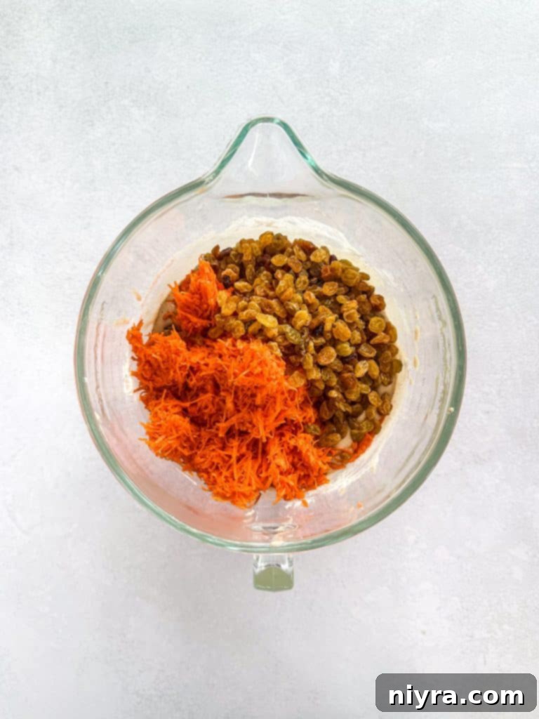 Mixing dry ingredients into wet ingredients for carrot cake