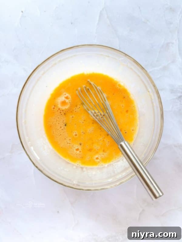 Golden Sausage Crescent Roll Bake 13 Pouring beaten eggs over casserole