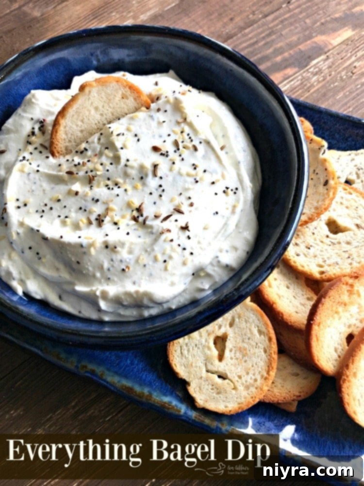 Everything Bagel Dip in a rustic blue bowl, garnished with fresh herbs.