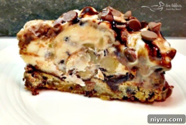 Slice of chocolate chip cookie dough ice cream cake with a whole cookie bottom.