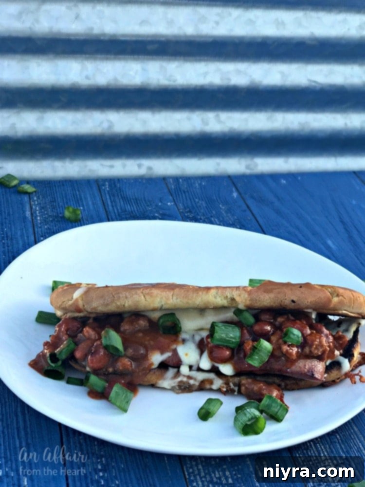 Spicy Grilled Cheese Chili Dogs on the grill with melted pepper jack cheese, a popular summer barbecue recipe.