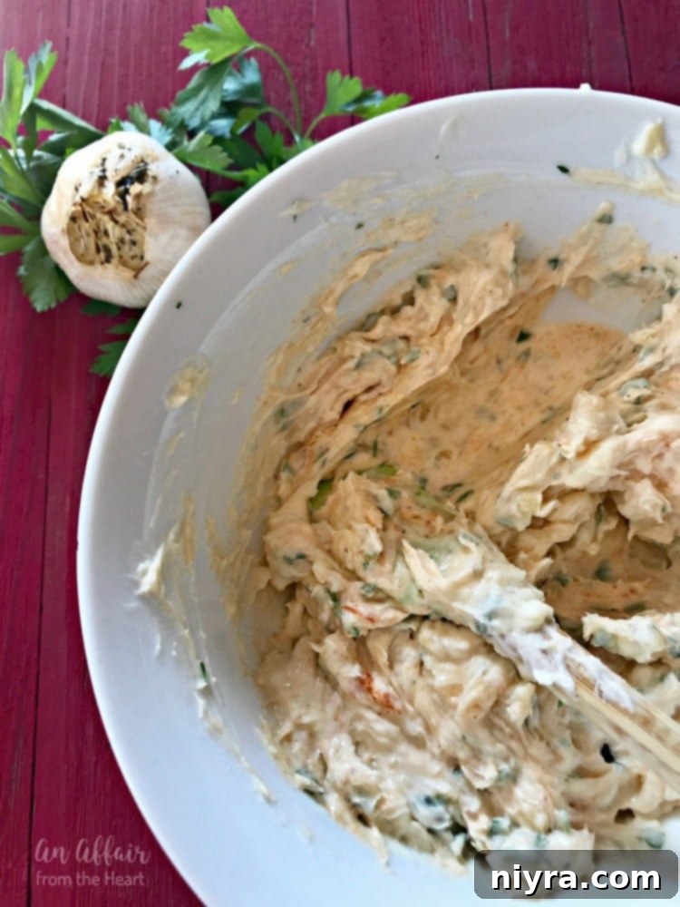 Rich, golden roasted garlic butter in a rustic white bowl, ready to be spread on your favorite bread